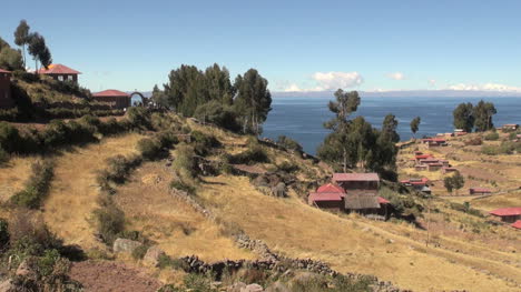 Peru-Taquile-Terrassierter-Hügel-Und-Entfernter-Steinbogen-In-Der-Nähe-Des-Sees-25