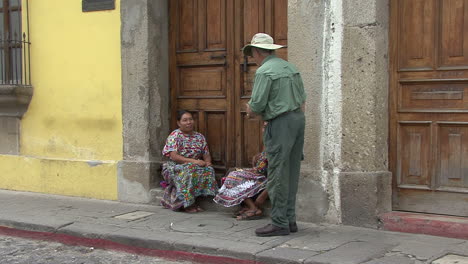 Guatemala-Antigua-Un-Turista-Conversa-Con-Mujeres-Locales-En-Traje-Tradicional