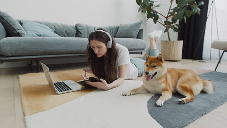 Young-Woman-Working-On-Her-Laptop-At-Home-Next-To-Her-Dog-2