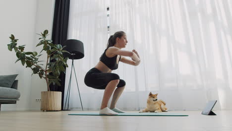 A-Young-Woman-Does-Yoga-At-Home-With-Her-Dog-Next-To-Her-1