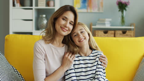 Porträt-Von-Mutter-Und-Tochter,-Die-Auf-Einer-Gelben-Couch-Sitzen-1