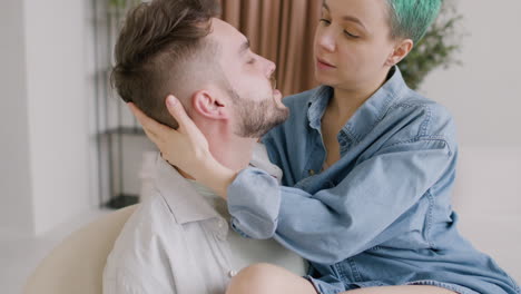 Close-Up-View-Of-Young-Couple-Talking-And-Hugging,-The-Guy-Holds-The-Girl-Sitting-On-A-Chair