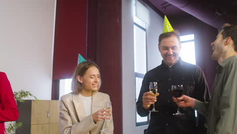 Multiethnic-Colleagues-With-Party-Hat-Toasting-And-Drinking-At-The-Office-Party