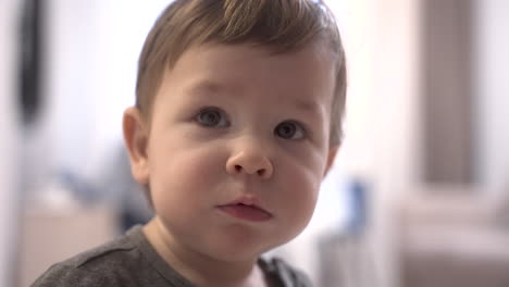 Close-Up-View-Of-A-Baby-Looking-At-Camera-At-Home