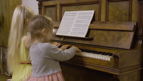Seitenansicht-Von-Zwei-Kleinen-Mädchen,-Die-Zu-Hause-Altes-Klavier-Spielen-1