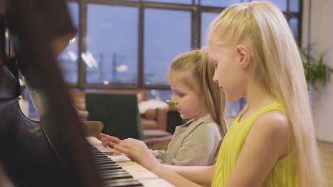 Side-View-Of-Two-Little-Girls-Playing-Old-Piano-At-Home-2