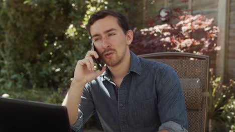 Man-working-from-home-talking-on-phone