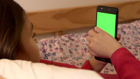 Una-Niña-Desplazándose-En-Un-Teléfono-Celular-De-Pantalla-Verde