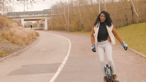 Slow-motion-of-attractive-Black-woman-riding-an-Electric-Unicycle,-Close-up