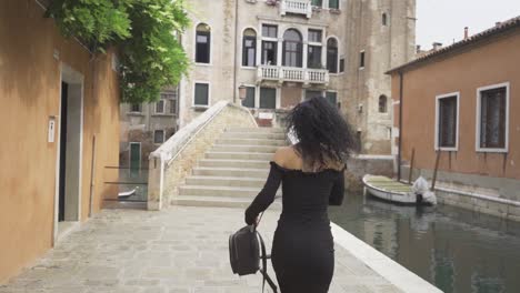 Curly-girl-walking-and-spinning-on-a-bridge-in-Venice-slow-motion