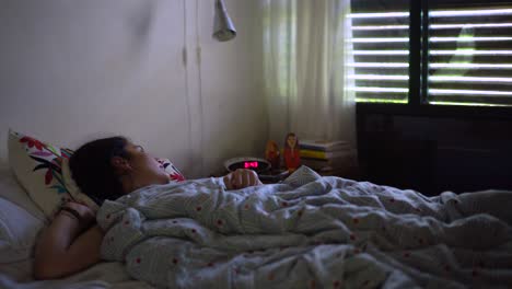 Young-girl-sleeping-on-the-bed,-sunlight-from-the-window