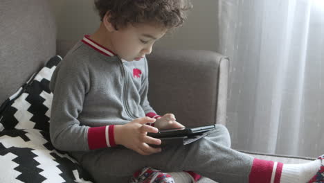 A-small-boy-plays-a-game-on-a-tablet-1