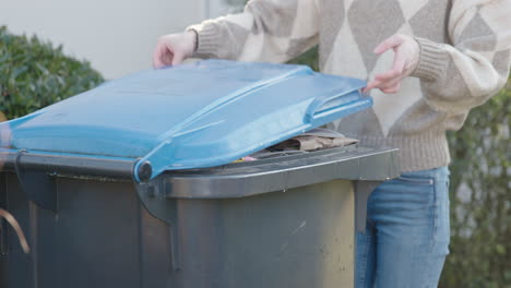 Woman-opens-blue-paper-bin-in-slow-motion