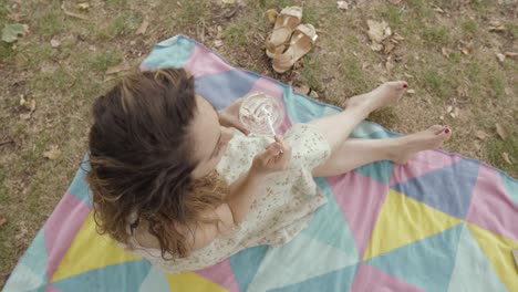 A-young-girl-is-eating-some-yoghurt-in-the-park-seated