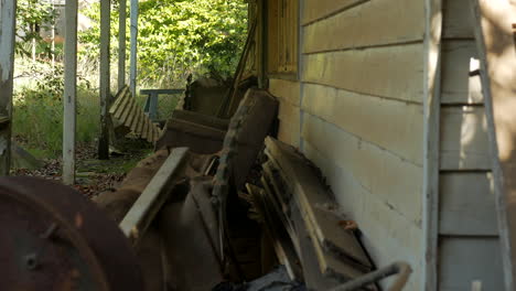 Abandoned-farm-house-with-junk-on-the-front-porch,-TITLT-UP