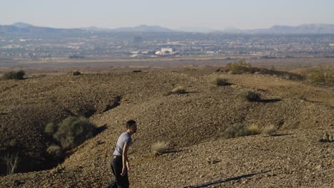 Ein-Junger-Mann-Macht-Sich-Auf-Den-Weg-Eine-Wüstenlandschaft-Hinauf,-Um-Das-Las-Vegas-Valley-Zu-Enthüllen