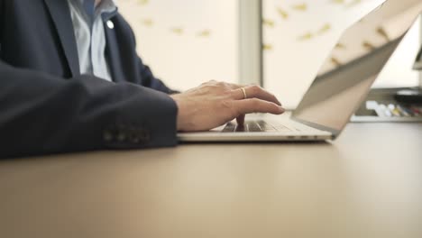 Business-man-clicking-on-his-macbook-and-writing