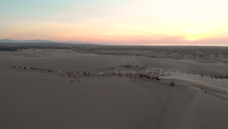 Panorama-Drohnenaufnahme-Von-Menschen,-Die-Auf-Den-Sonnenaufgang-In-Den-Dünen-In-Mui-Ne,-Vietnam,-Warten