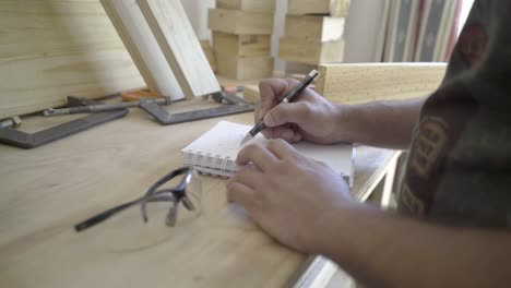 Close-up-shot-of-craftsman-sketching-a-project-design-in-his-workshop