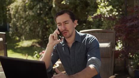 Hombre-Trabajando-Desde-Casa-En-El-Jardín-Por-Teléfono