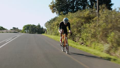 Tracking-Shot-of-a-Young-Male-Road-Cyclist-Racing-Down-a-Hill