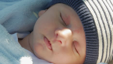 Bebé-Recién-Nacido-Durmiendo-Afuera-Al-Sol-Con-Un-Gorro-De-Punto