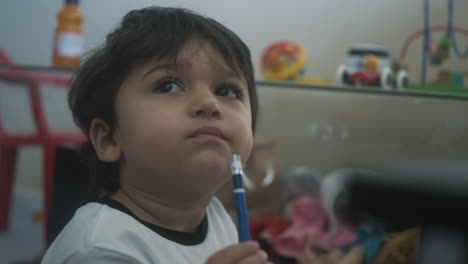 Young-toddler-infant-child-chews-on-a-pencil-eraser-while-playing-at-home