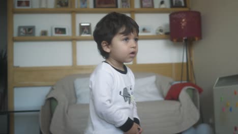 Young-child-walking-and-dancing-in-the-living-room-while-watching-TV