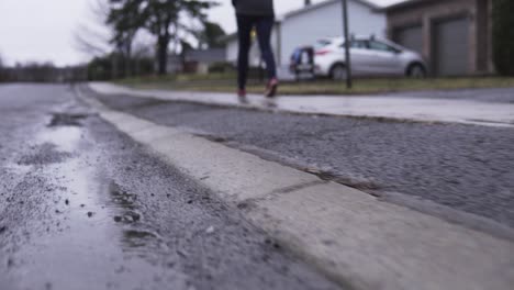 Teenage-girl-walking-down-sidewalk-on-rainy-day