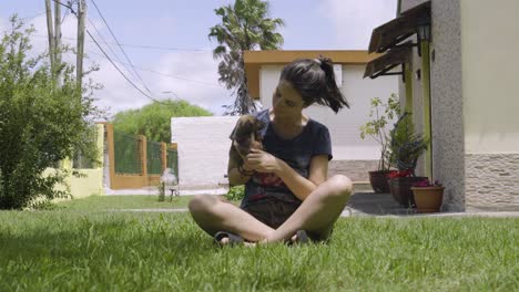 Young-Girl-Playing-with-a-Little-Puppy-in-the-Green-Yard,-Long-Shot