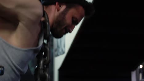 Young-beard-male-athlete-in-sportswear-doing-dips-on-parallel-bars-in-the-gym