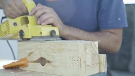 Close-up-shot-of-power-tool-electric-plane-machine-working-on-a-wood-post