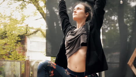 A-young-and-fit-woman-keeping-her-hands-up-in-the-air-during-a-yoga-lesson