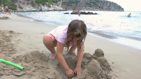 Girl-playing-on-the-beach-building-sand-castle