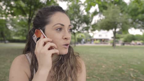 Una-Joven-Está-Hablando-Por-Teléfono-Con-Su-Amiga-Y-Mostrando-Cosas-Con-La-Mano