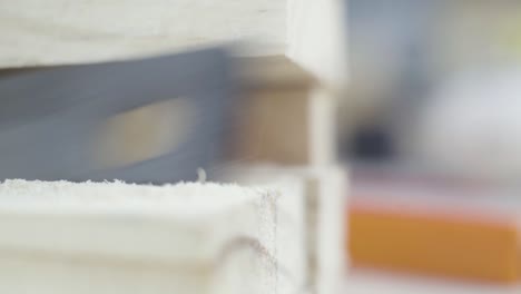 Detail-shot-of-saw-teeth-cutting-through-wood-with-sawdust-and-debris