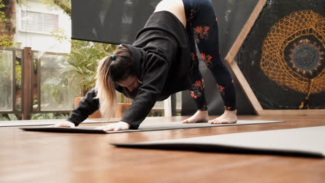 Toma-En-Cámara-Lenta:-Una-Estudiante-De-Yoga,-En-Un-Salón-De-Clases,-Practica-Un-Ejercicio-Para-Flexionar-Y-Estirar-Los-Músculos-De-La-Espalda-Y-Los-Hombros