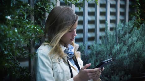 Attractive-teenage-girl-reads-e-book-on-kindle-with-wind-moving-her-hair