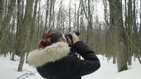 Fotografin-Mit-Rosa-Haaren,-Die-Im-Winterwald-Fotografiert