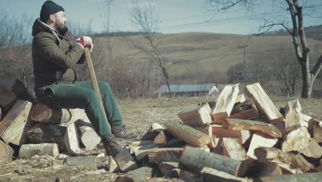 Man-resting-after-cracking-firewood-for-the-winter