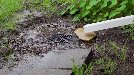 Rain-water-coming-out-of-a-downspout-into-a-catch-basin-in-slow-motion