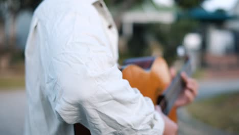 Young-Male-Artist-Walking-In-The-Street-While-Playing-An-Acoustic-Guitar