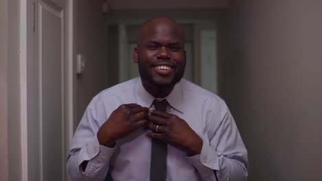 A-man-puts-a-tie-on-his-neck,-while-smiling-broadly-in-front-of-the-mirror