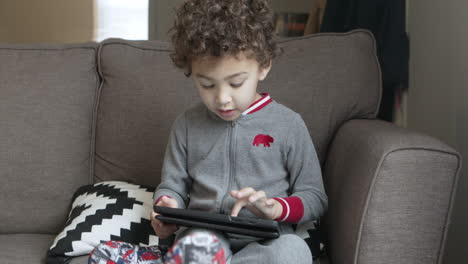 A-small-boy-plays-a-game-on-a-tablet