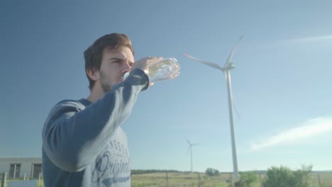 Junger-Mann-Stoppt-Sein-Radfahren,-Um-Sich-Auszuruhen-Und-Etwas-Wasser-Aus-Einer-Plastikflasche-Zu-Trinken