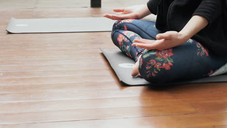 A-yoga-student-in-a-class-during-a-lesson,-practising-the-lotus-position-technique