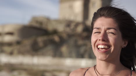 Las-Mujeres-Jóvenes-Miran-A-Su-Alrededor-En-La-Playa,-Con-El-Pelo-Azotado-Por-El-Viento