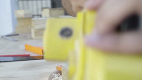 Close-up-shot-of-electric-planer-power-tool-planing-wood-by-a-craftsman-tradesman