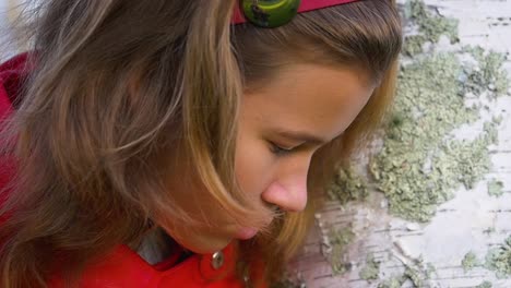 Attractive-teenage-girl-peeling-off-silver-birch-bark