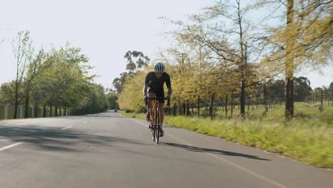 Low-Tracking-Out-Shot-of-a-Male-Road-Cyclist-Slowly-Pedaling-Up-a-Hill